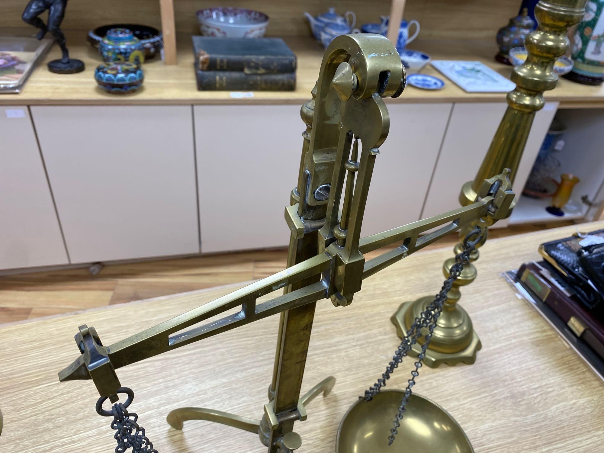 A pair of brass altar candlesticks, 60cm and a pair of Beam scales to weight 2lb, height 56cm